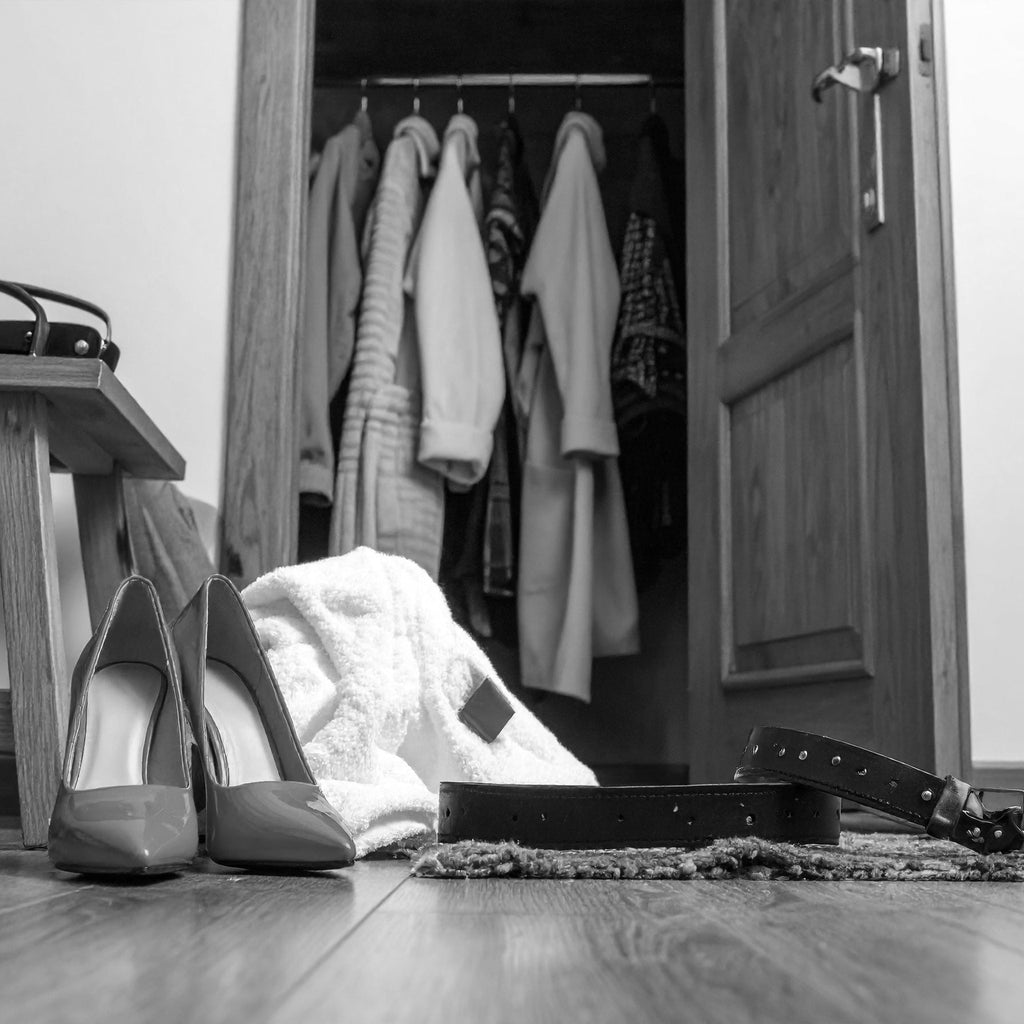 schwarz/weiß Bild von einem offen Schrank,  im Vordergrund stehen HighHeels